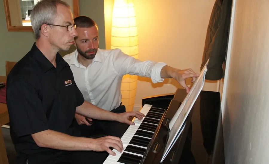 James Barnett guiding a student at the piano